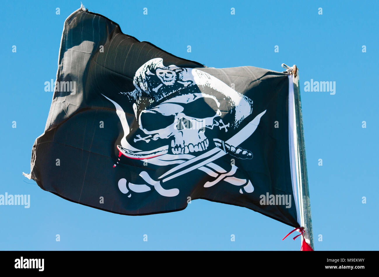 Schwarze und weiße Totenkopf Piratenflagge auf einem Fahnenmast. Stockfoto