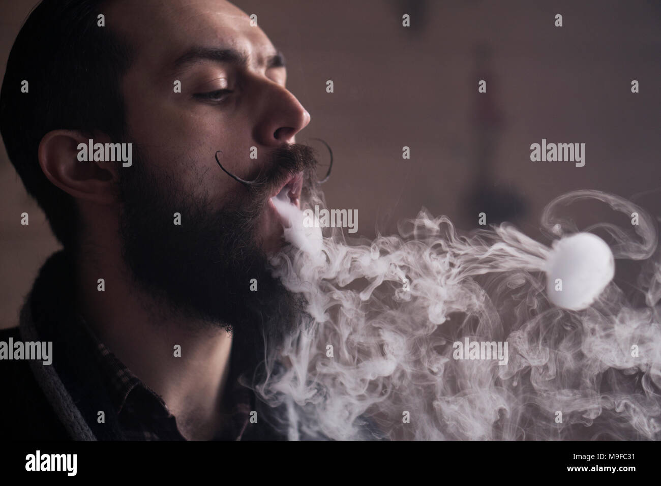 Mann mit Bart und Mustages Vaping eine elektronische Zigarette. Vaper  Hipster Rauch Vaporizer und Exhals Rauch Ringe Stockfotografie - Alamy