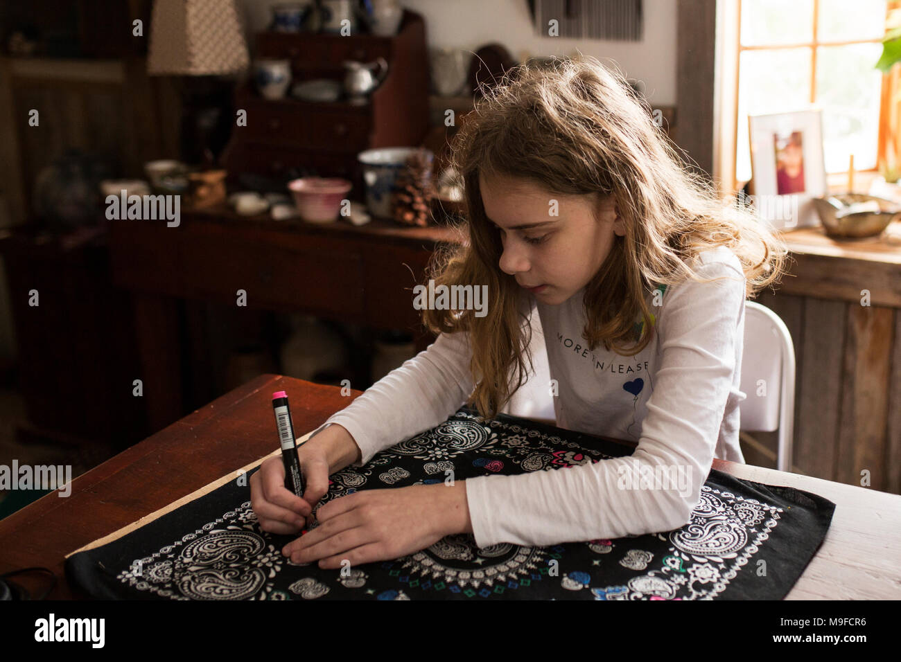 Ein elf Jahre altes Mädchen Farben ein Gewebe bandanna mit Markierungen. Stockfoto