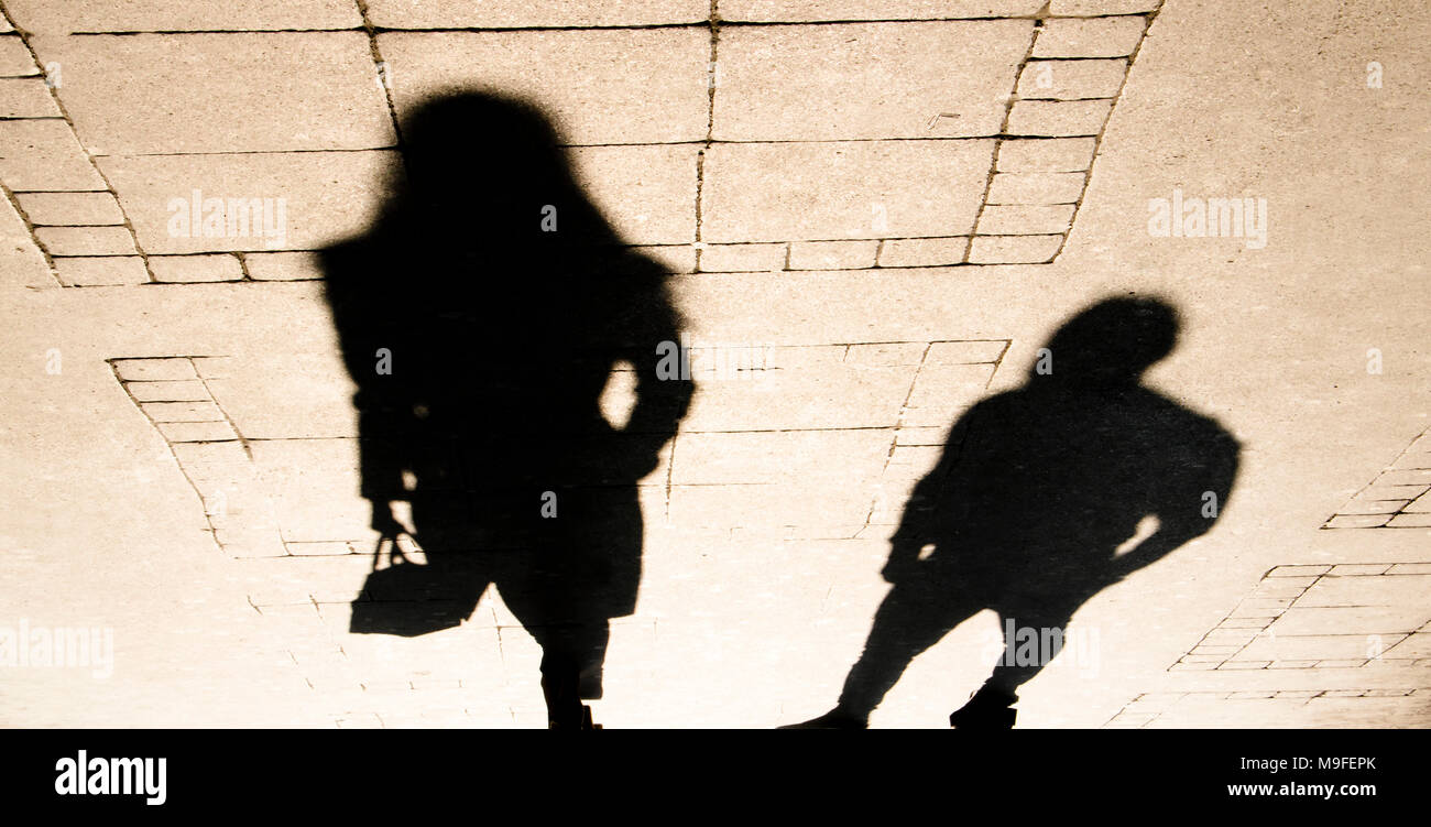 Silhouette Schatten von einer Frau und einem Mann auf Stadt Bürgersteig in sepia schwarz und weiß Stockfoto