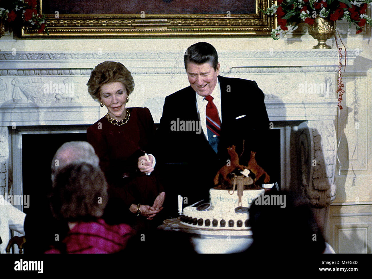 Washington, DC., USA < Februar 5, 1988 Präsident Ronald Reagan und First Lady Nancy Reagan im East Room des Weißen Hauses mit einem Kuchen und Kerzen für 77. Geburtstag des Präsidenten. Credit: Mark Reinstein/MediaPunch Stockfoto