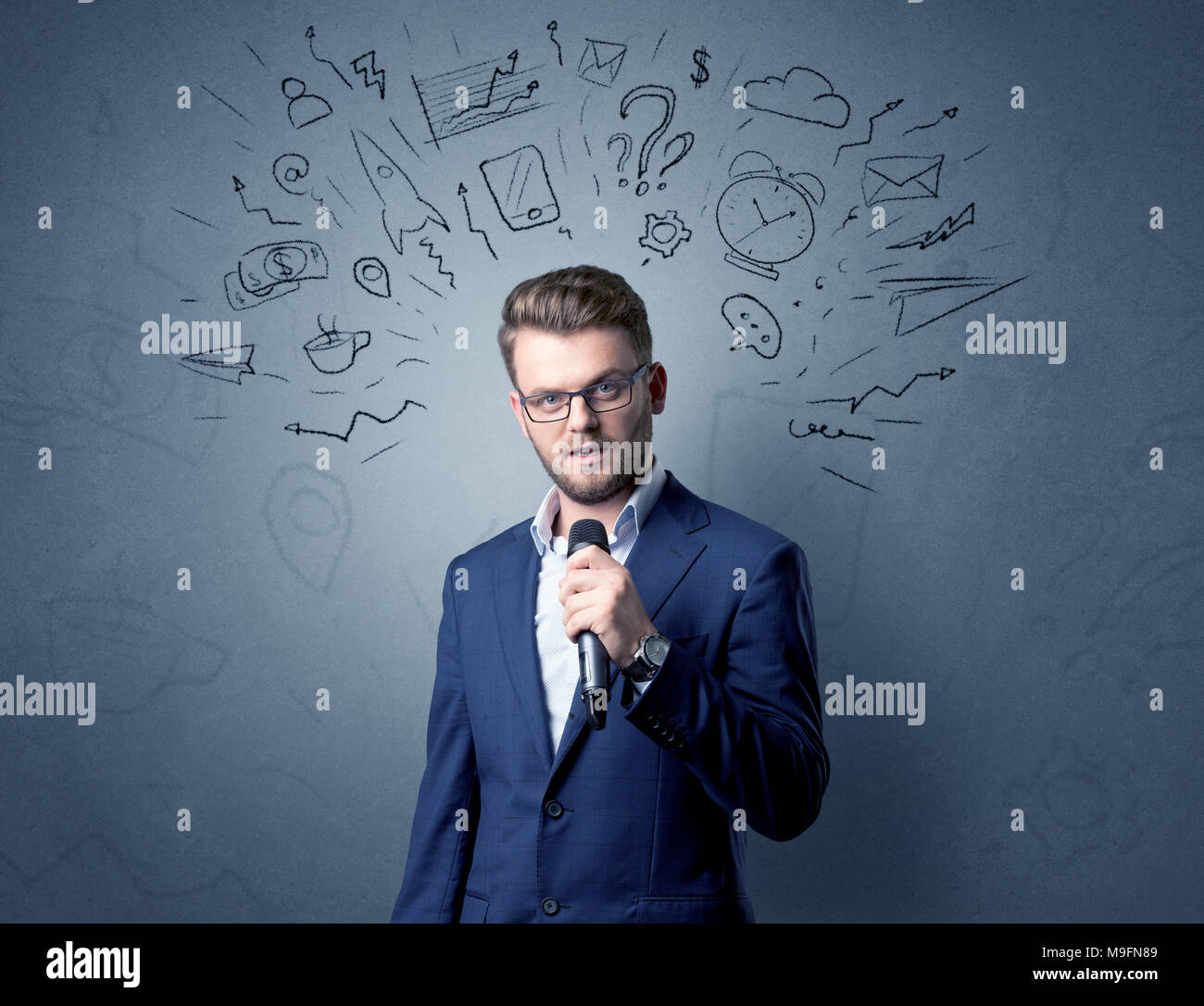 Geschäftsmann sprechen in das Mikrofon mit gemischten Doodles über seinem Kopf Stockfoto