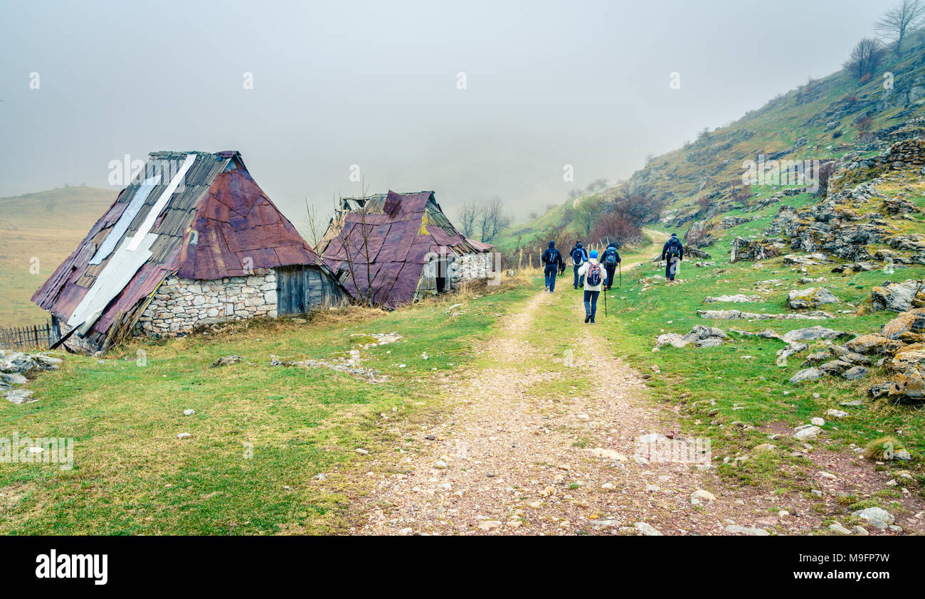 Wanderer zu Fuß durch die verfallenen Gebäude in einem alten bosnischen Dorf in den Bergen Stockfoto