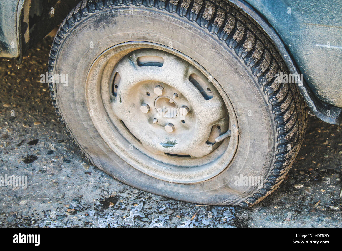Beschädigte Reifen von einem alten Auto auf der Straße mit selektiven Fokus Stockfoto