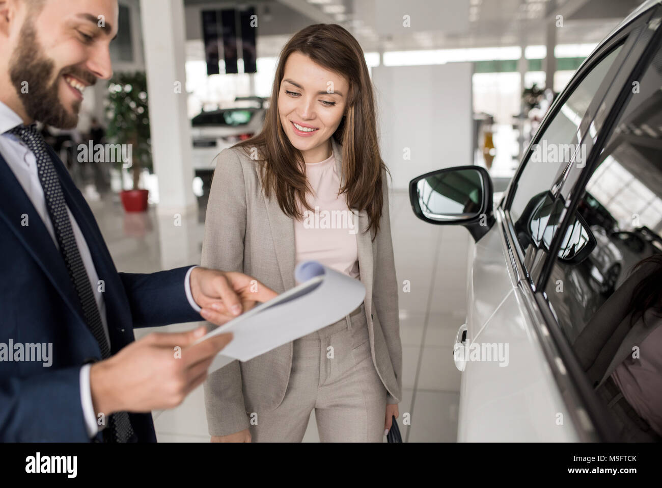 Schöne Frau zu sprechen Verkäufer im Autohaus Stockfoto