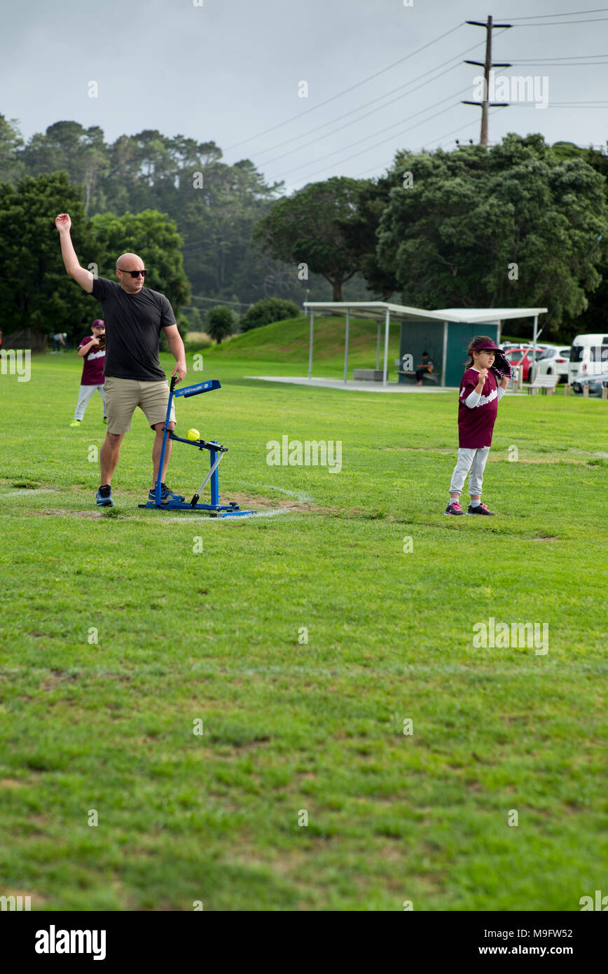 Ein erwachsener verwendet ein Pitching Machine folgenden Obwohl mit Pitching arm Aktion bei Junior Softball. Stockfoto