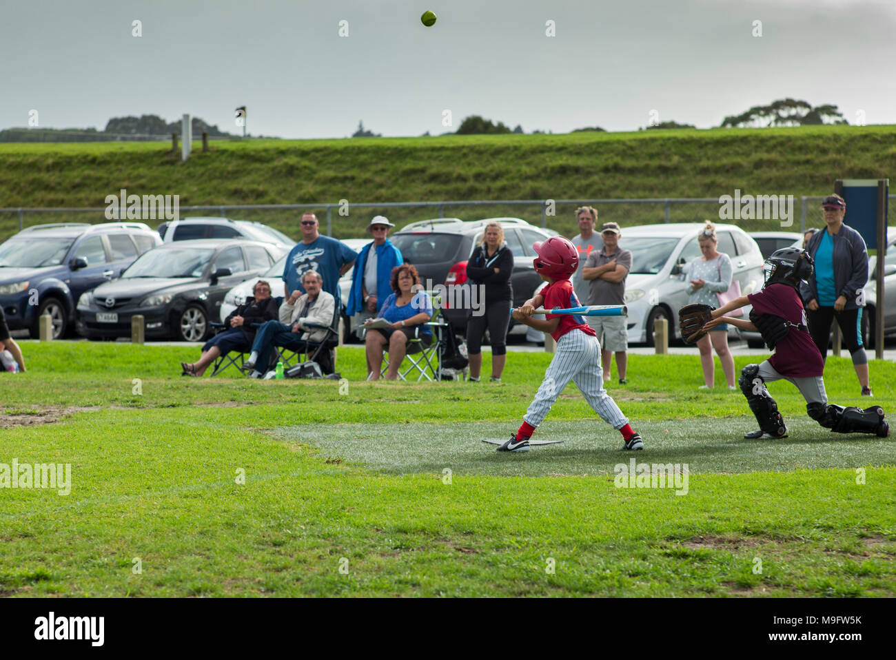 Eine junge Softball Spieler schlägt die Kugel für ein Foul in einem Softball Spiel. Stockfoto