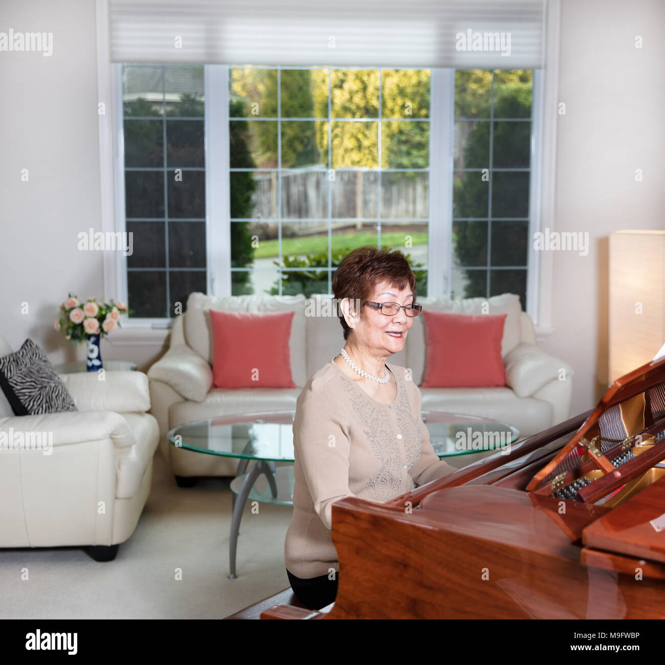 Ältere Frau Klavier spielen mit Freude Stockfoto