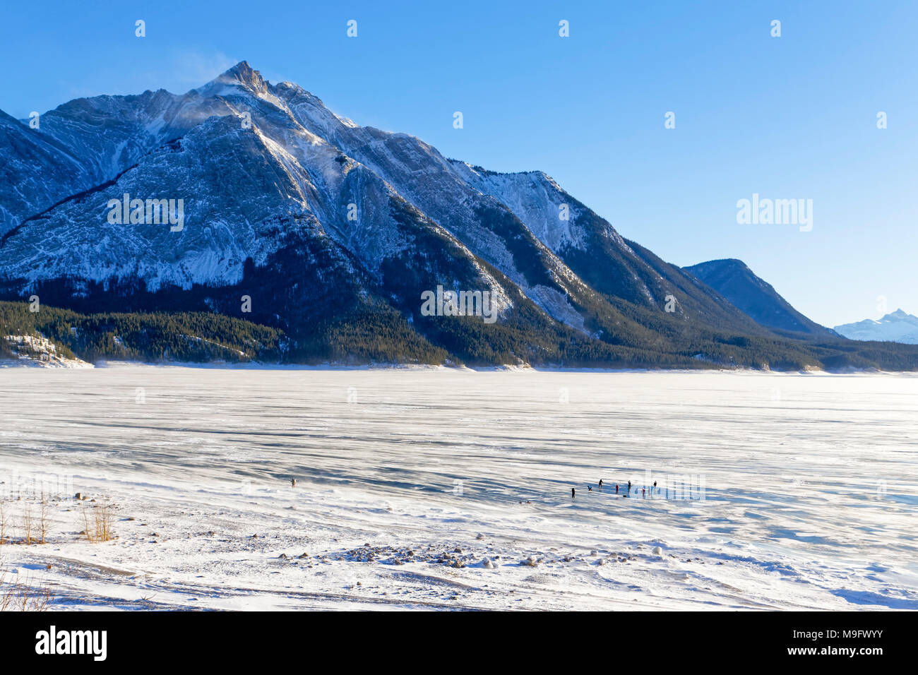 42,747.08405 snowy Abraham Lake mit Blue Ice 9 entfernten Fotografen bei der Arbeit, und die Berge im Hintergrund, Nordegg, Alberta Kanada, Nordamerika Stockfoto