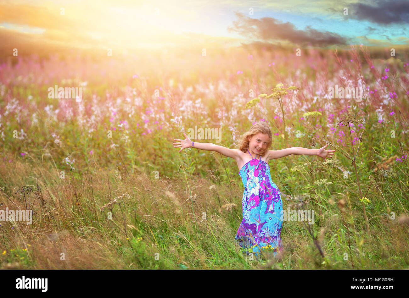 Fröhlich tanzenden Mädchen in einem Feld von Blumen Stockfoto