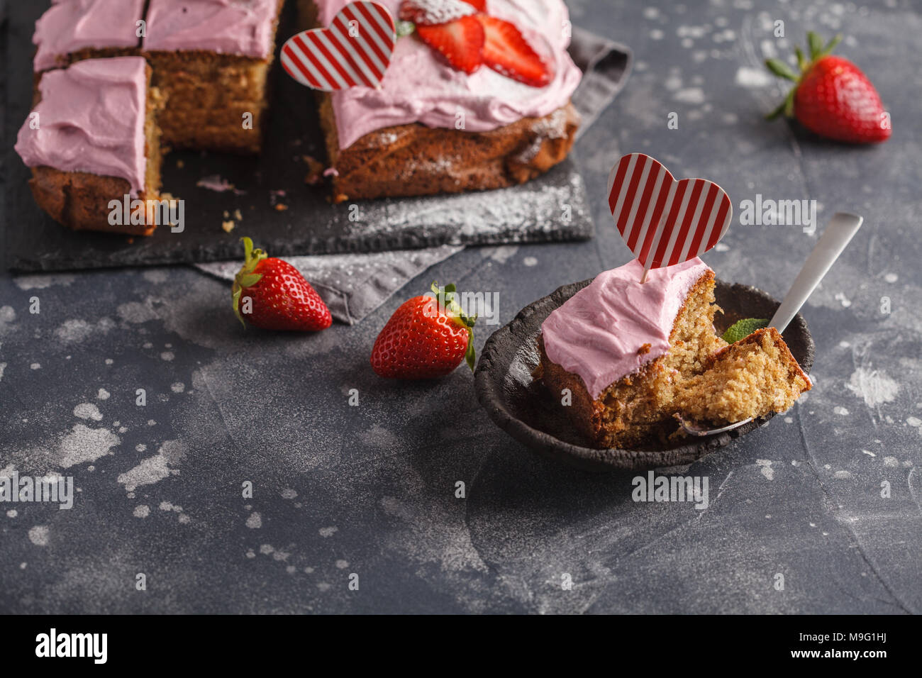 Valentinstag Kuchen zum Frühstück mit rosa Glasur und frische Erdbeeren. Dunkler Hintergrund, Sommer Nachtisch. Stockfoto