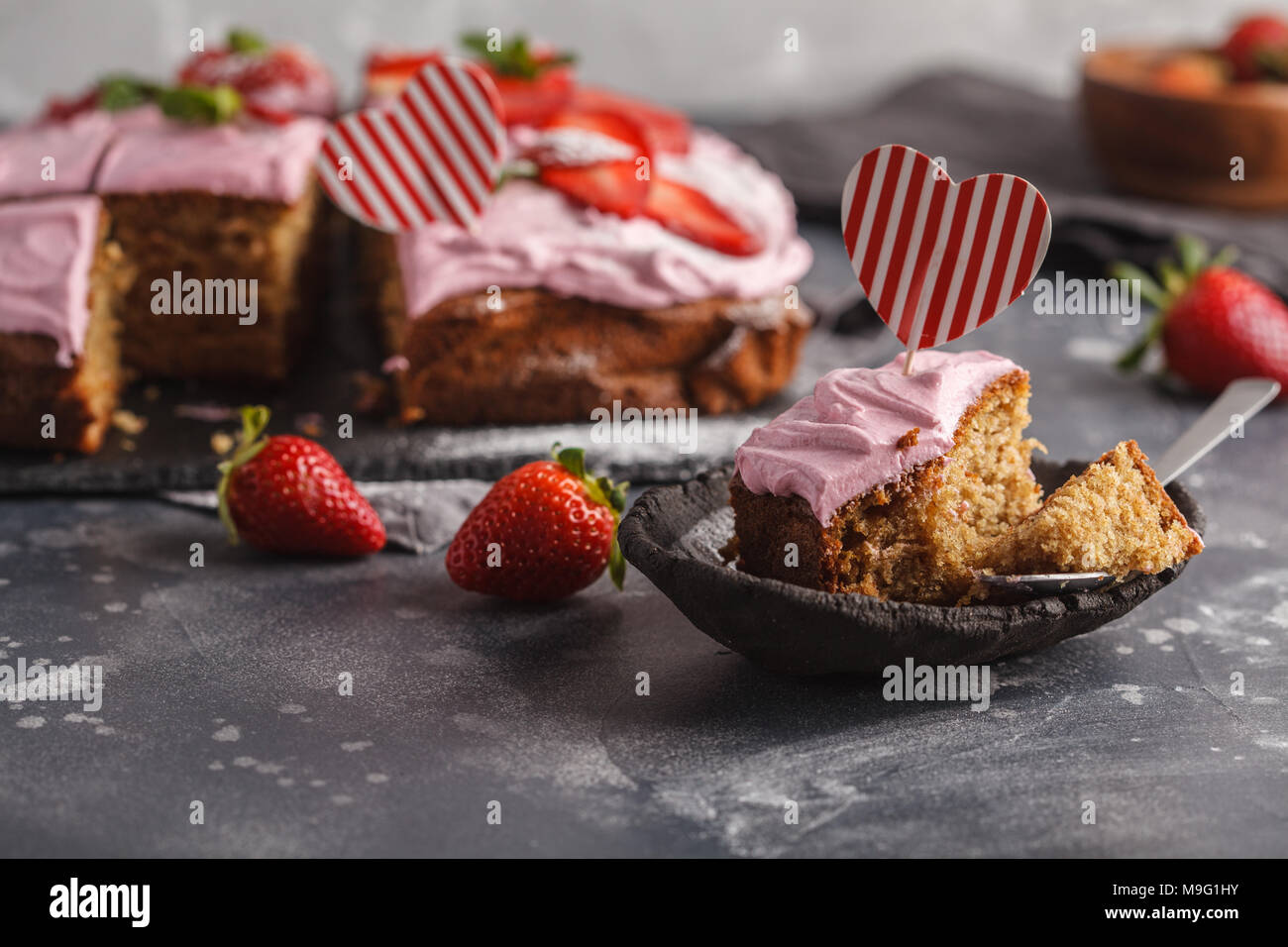 Valentinstag Kuchen zum Frühstück mit rosa Glasur und frische Erdbeeren. Dunkler Hintergrund, Sommer Nachtisch. Stockfoto