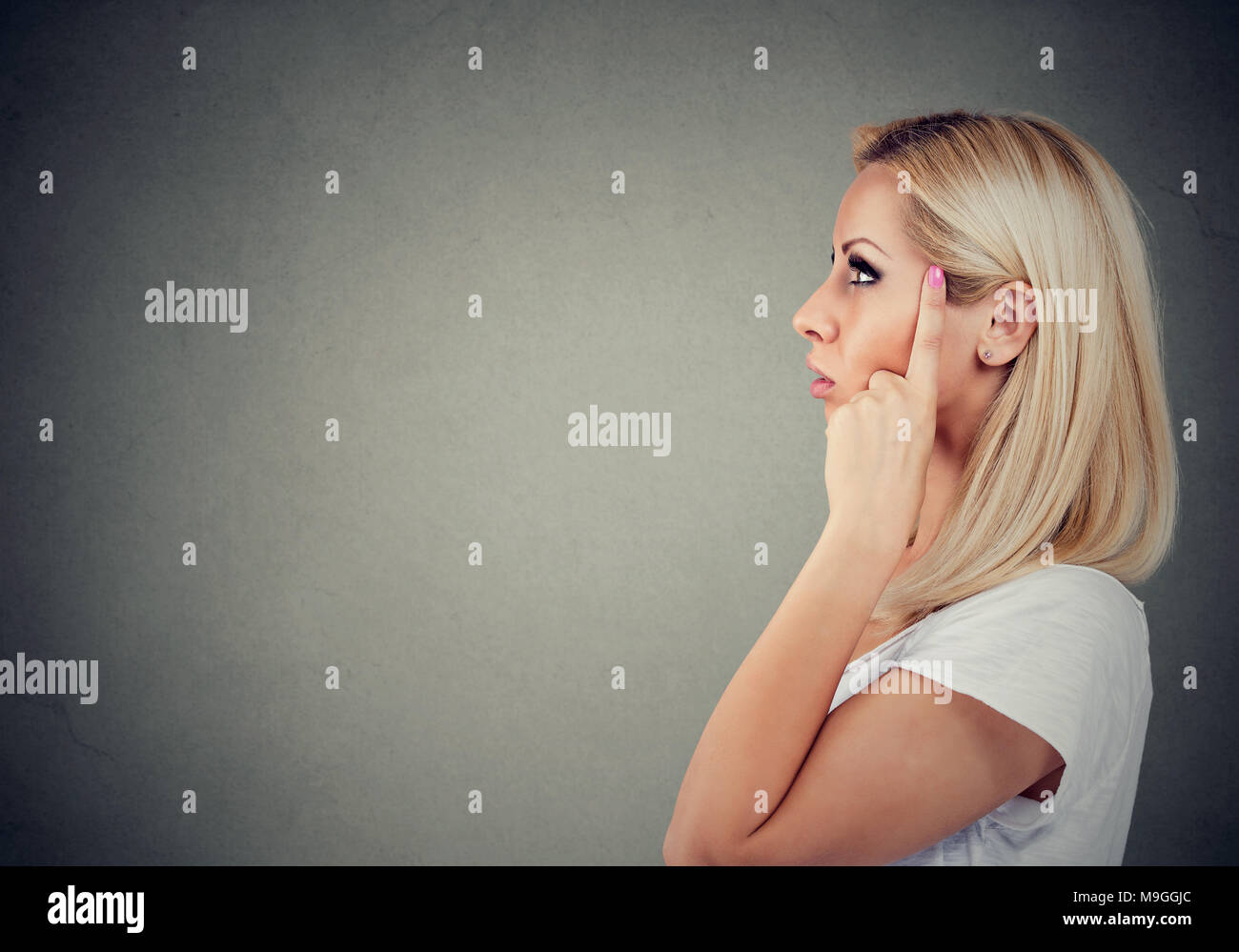 Seitenansicht des beiläufigen blonde Mädchen berühren Tempel und Lösung des Problems entfernt. Stockfoto