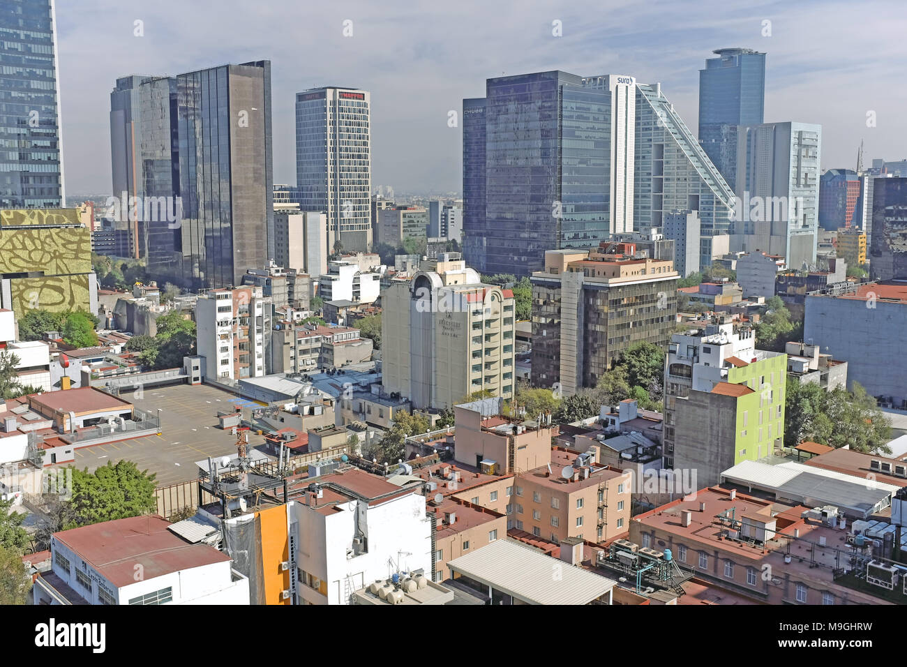 Die entfernten Wolkenkratzer der Finanzdistrikt in Mexiko City, Mexiko tower über die benachbarten Zona Rosa Viertel in den Vordergrund. Stockfoto