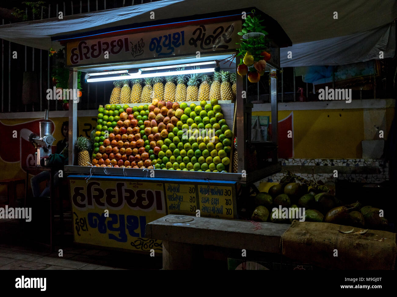 Ort: Ahmedabad, Gujarat, Indien. Aufnahmedatum: März -25-2018. Foto von lokalen Saft street Hersteller auf den Straßen von Indien anzeigen Früchte auf Warenkorb. Stockfoto