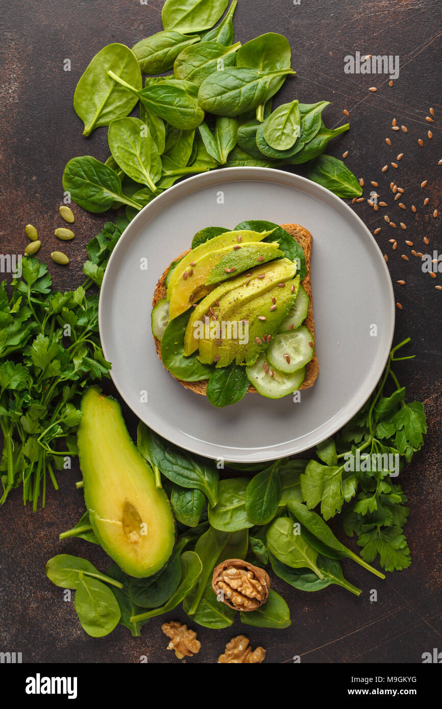 Frisches Frühstück avocado Sandwich. Grüner Salat und Sonnenblumenkerne, gesunde vegane Ernährung Konzept. Essen Hintergrund. Ansicht von oben, kopieren. Stockfoto