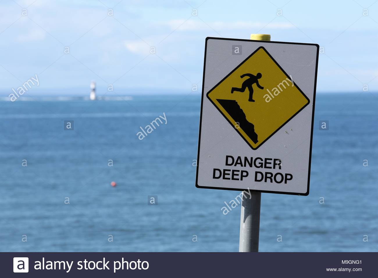 Eine gelbe Gefahr tiefen drop Schild warnt die Menschen gegen das in der Nähe einer steilen Klippe an der Westküste von Irland. Stockfoto