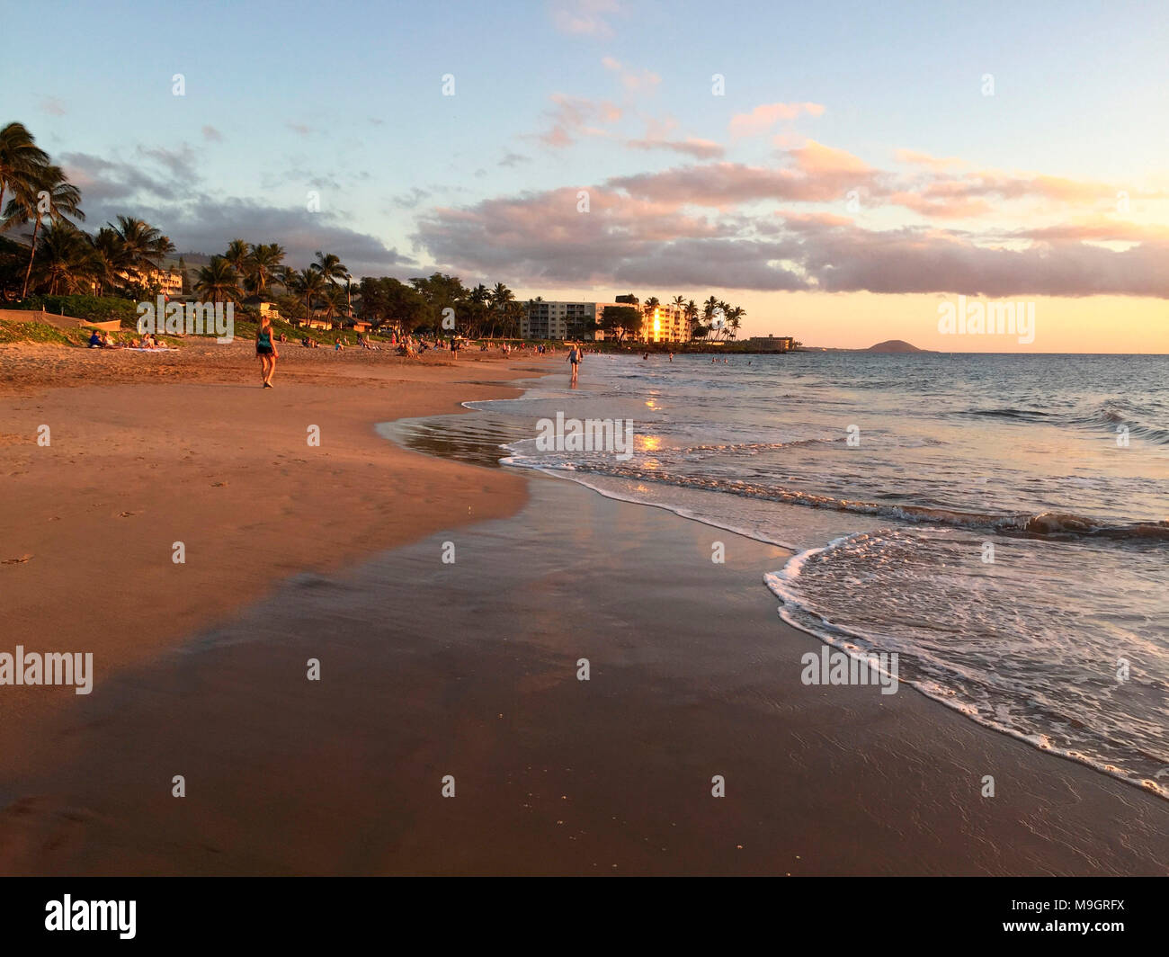Sand und Wellen auf Charley Young beach Glühen im schwindenden Licht der untergehenden Sonne, South Kihei, Maui, Hawaii, USA Stockfoto