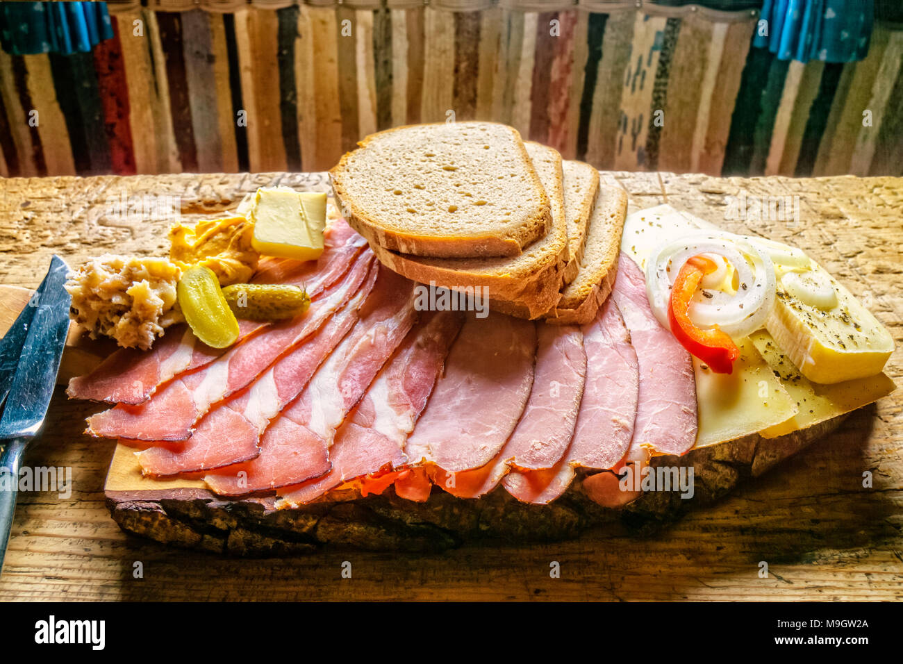 Rustikaler Aufschnitt, auf einem Baum Schicht in einer österreichischen Berghütte serviert. Stockfoto