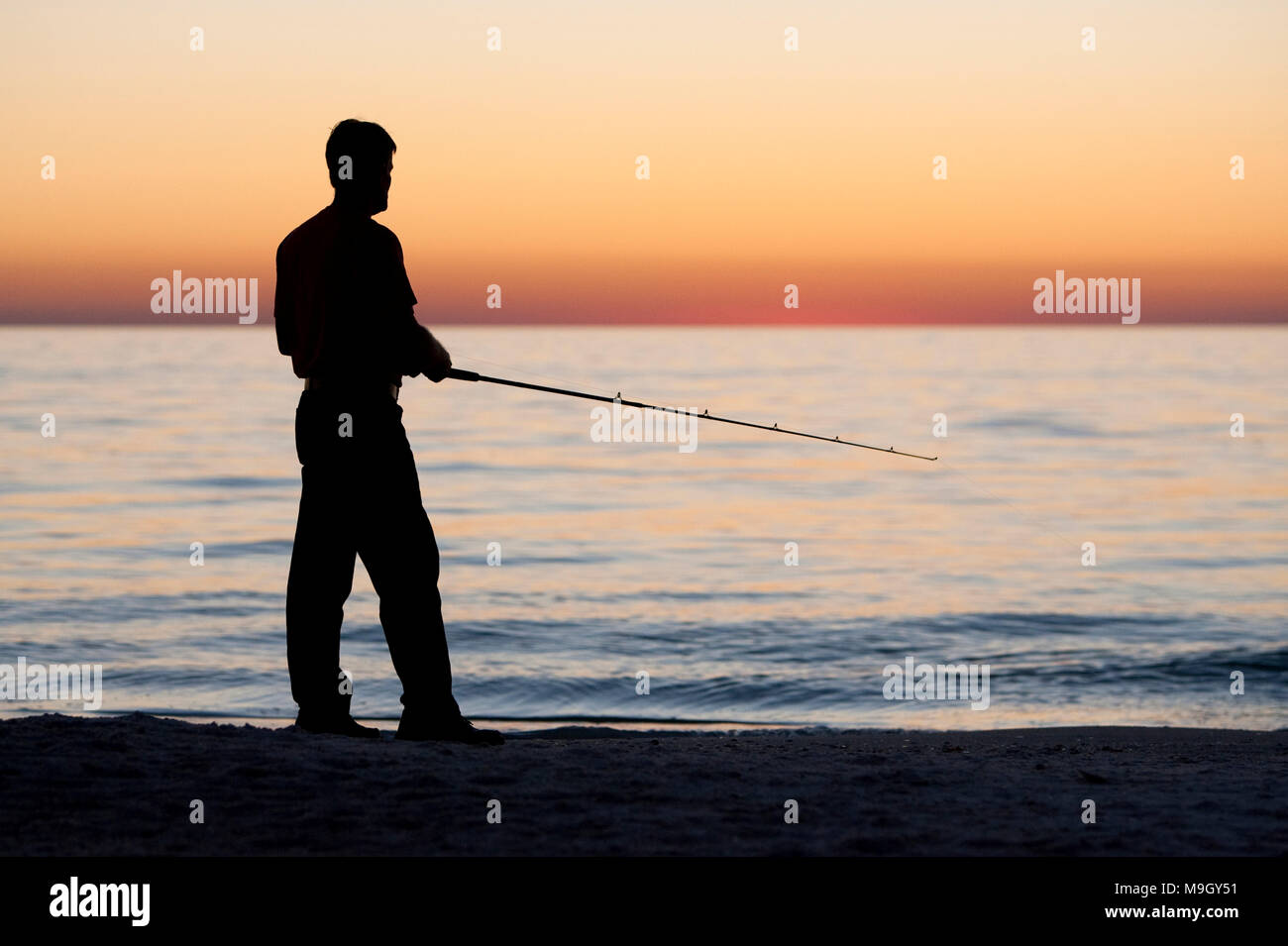Ein Mann Fische in den ruhigen Wassern des Golfs von Mexiko auf Anna Maria Island, Florida. Stockfoto