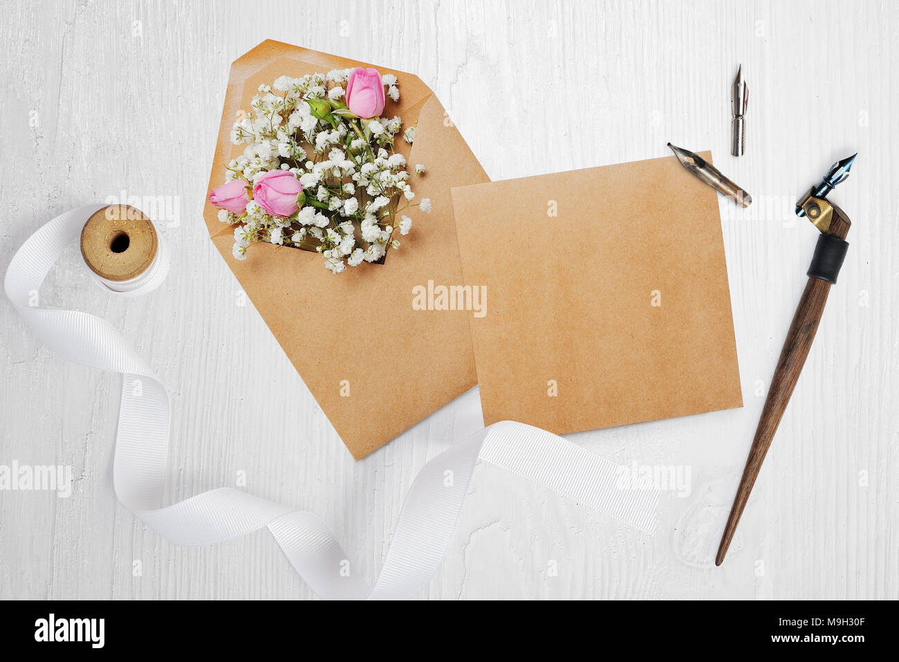 Kalligrafische Feder einen Umschlag mit Blumen und einem Brief, Grußkarte für Valentines Tag mit Platz für Ihren Text. Flach, Ansicht von oben Foto Mock up Stockfoto