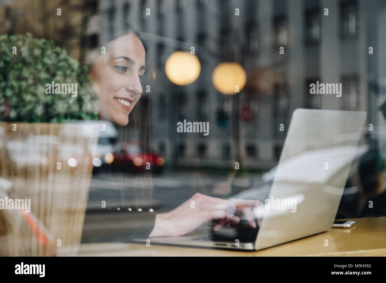 Weibliche Freelancer, eine Frau allein sitzen in einem Fenster Cafe, Arbeiten am Laptop aus dem Büro. attraktive Mode Blogger einen Blog schreiben Post auf Ihre Comp Stockfoto