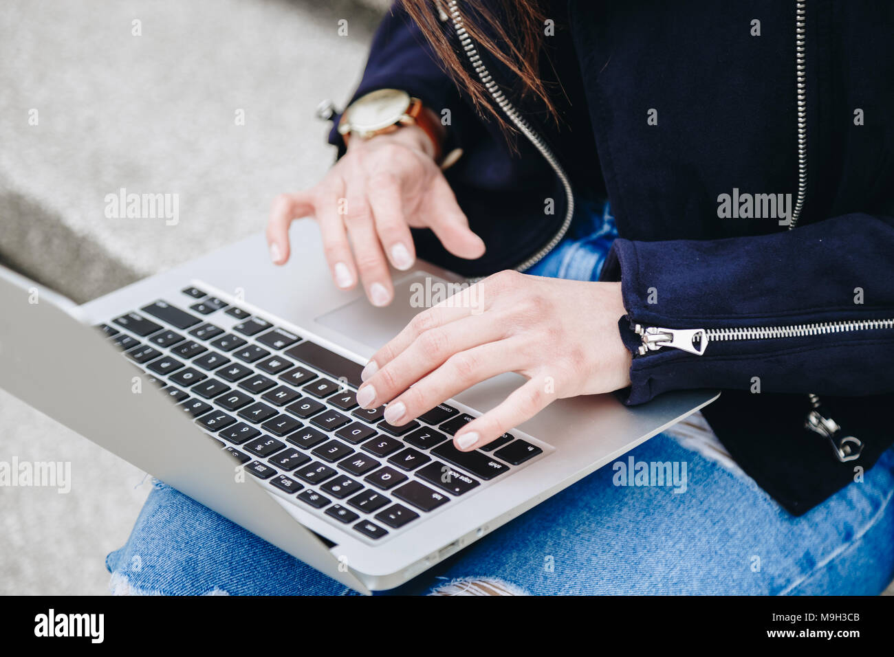 Junge und attraktive Mode blogger Schreiben einer neuen Blog-Eintrag auf Ihrem Laptop. attraktive Frau mit der pc im Freien, das Tragen einer Armbanduhr. Stockfoto