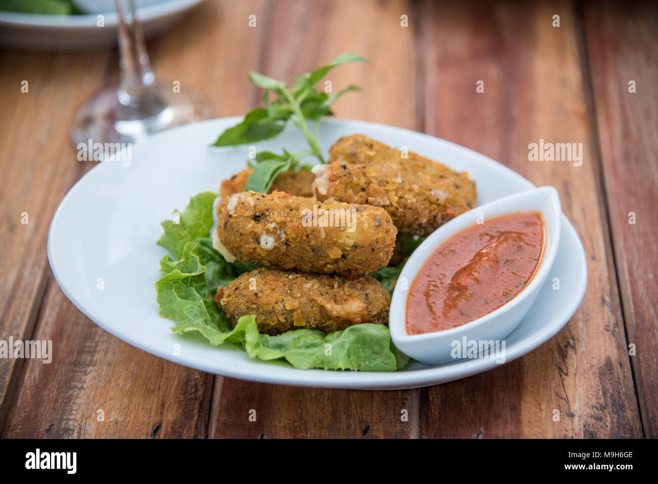 Nahaufnahme der gebratenen Mozzarella Sticks und Soße sitzen auf hölzernen Picknicktisch. Stockfoto