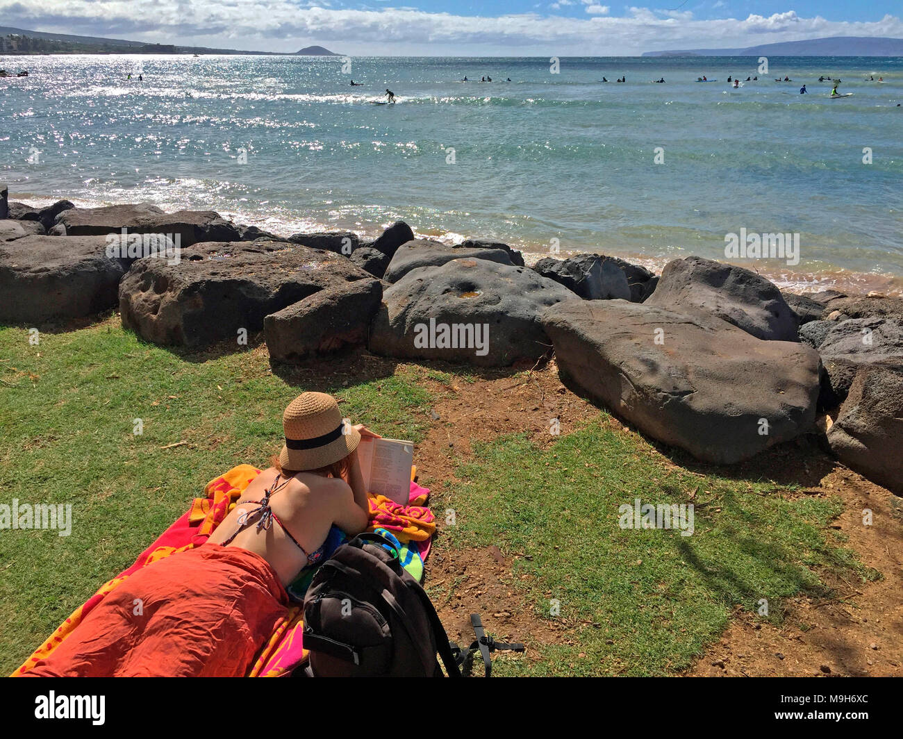 Eine youngwoman stützenden, Entspannen und Lesen in Kalama Park, mit Blick auf den Ozean in South Kihei, Maui, Hawaii, USA Stockfoto