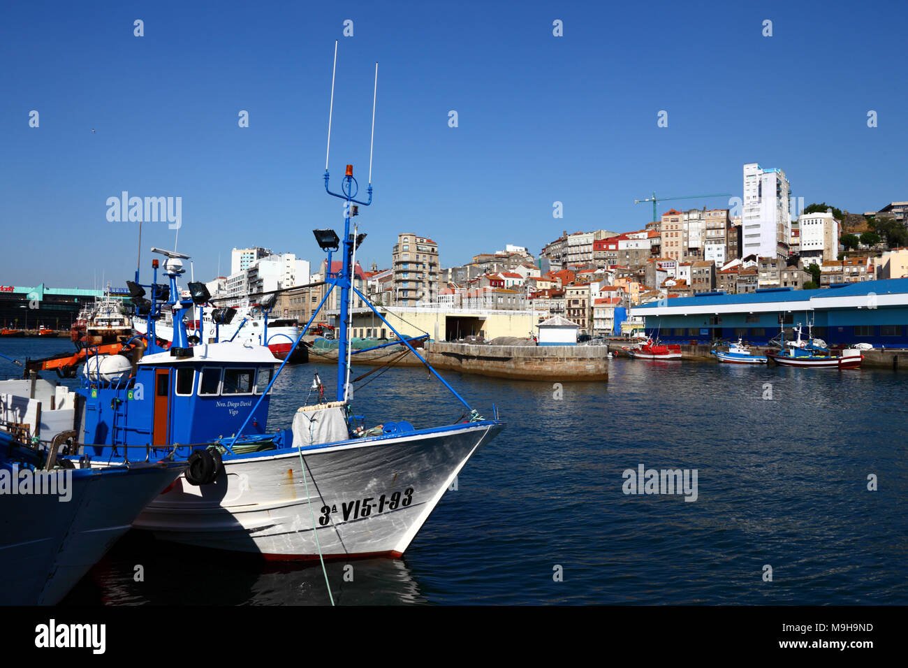 Fischerboote im Hafen und Gebäude am Hang, Vigo, Galicia, Spanien Stockfoto
