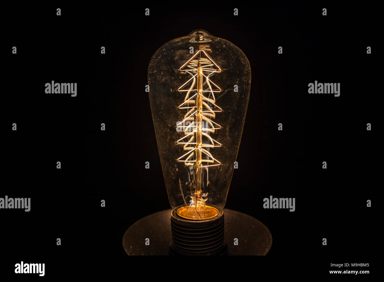 Vintage weißglühende Glühlampe Filament auf schwarz. Stockfoto