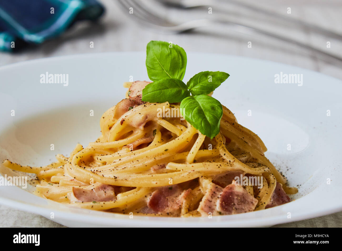 Spaghetti Carbonara auf weißem palte mit Basilikum Blatt Stockfoto