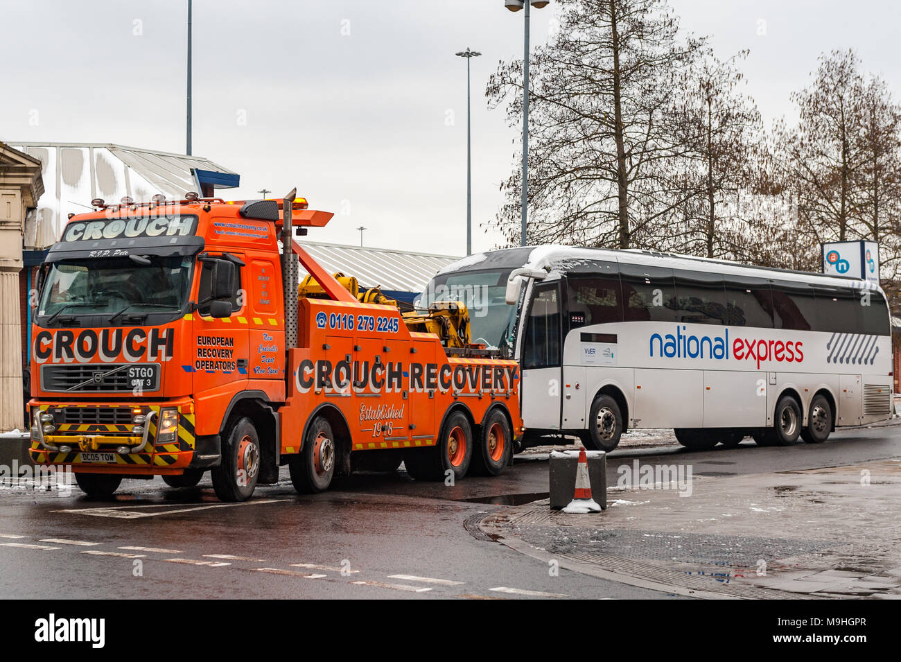 Schwertransporte Abschleppwagen abschleppen eines National Express Coach ab Pool Meadow Busbahnhof, Fairfax Street, Coventry, West Midlands, UK. Stockfoto