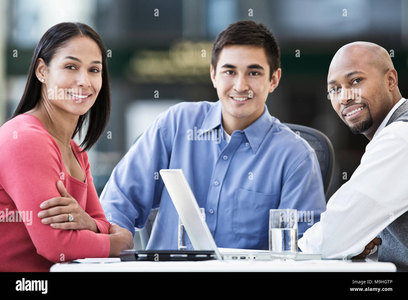Mixed Race Team von Geschäftsleuten an einem Tisch in einem Business Center. Stockfoto
