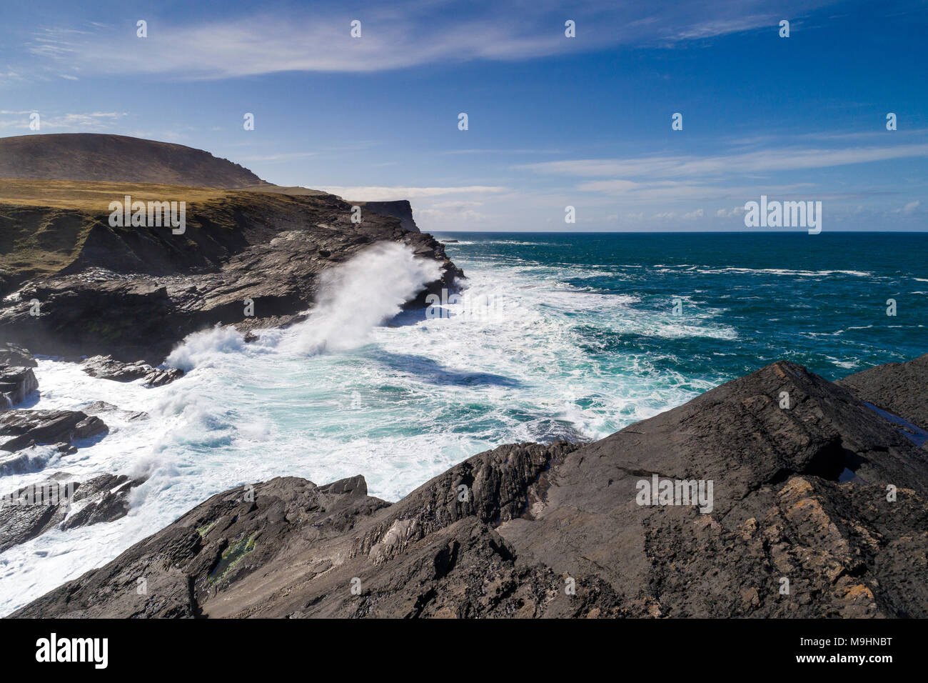 Wellen gegen die Klippen auf der Nordseite von Valentia Island, County Kerry, Irland Stockfoto