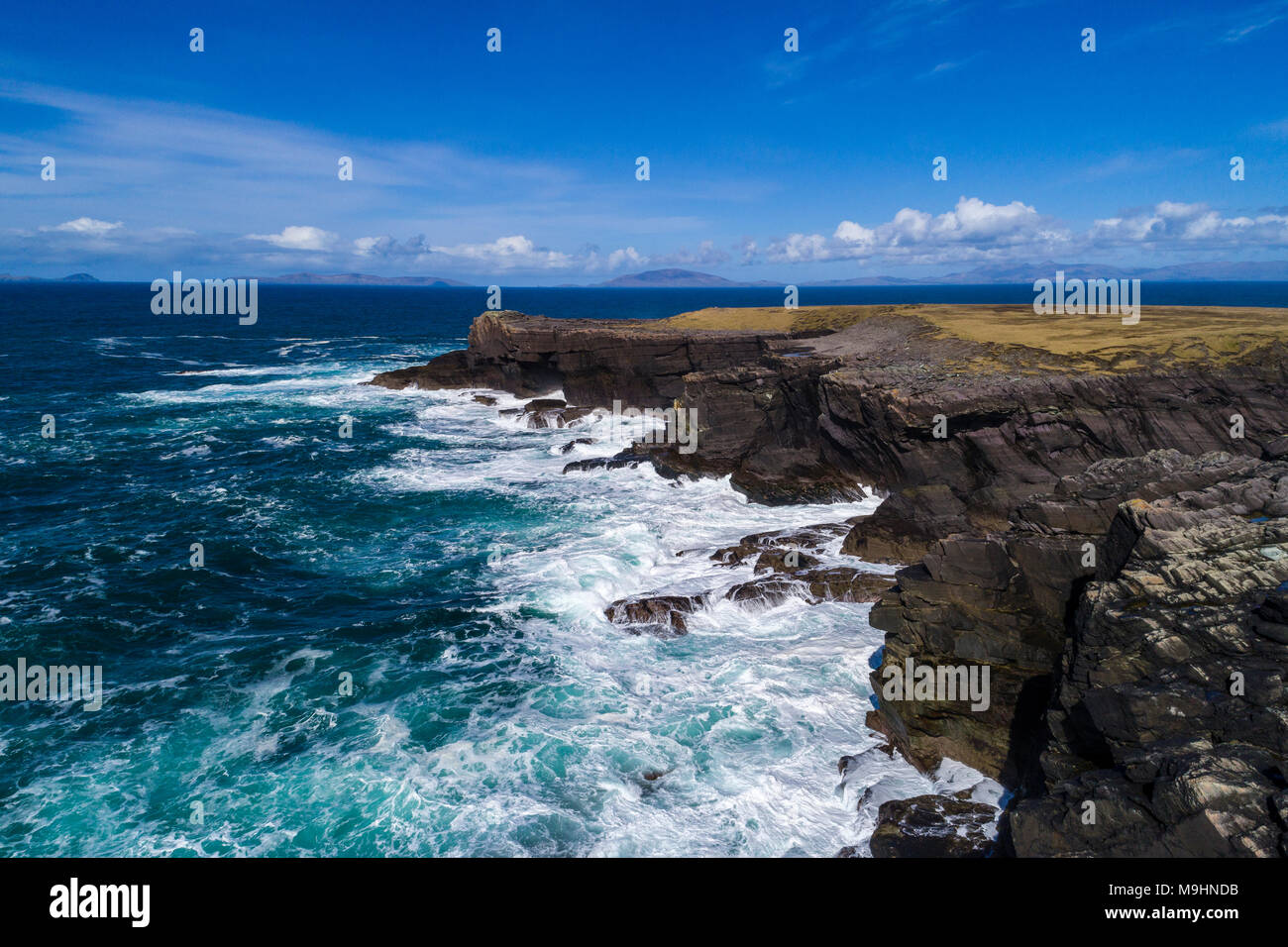 Wellen gegen die Klippen auf der Nordseite von Valentia Island, County Kerry, Irland Stockfoto