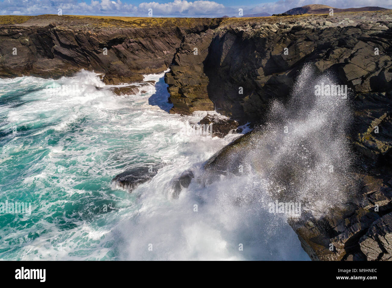 Wellen gegen die Klippen auf der Nordseite von Valentia Island, County Kerry, Irland Stockfoto