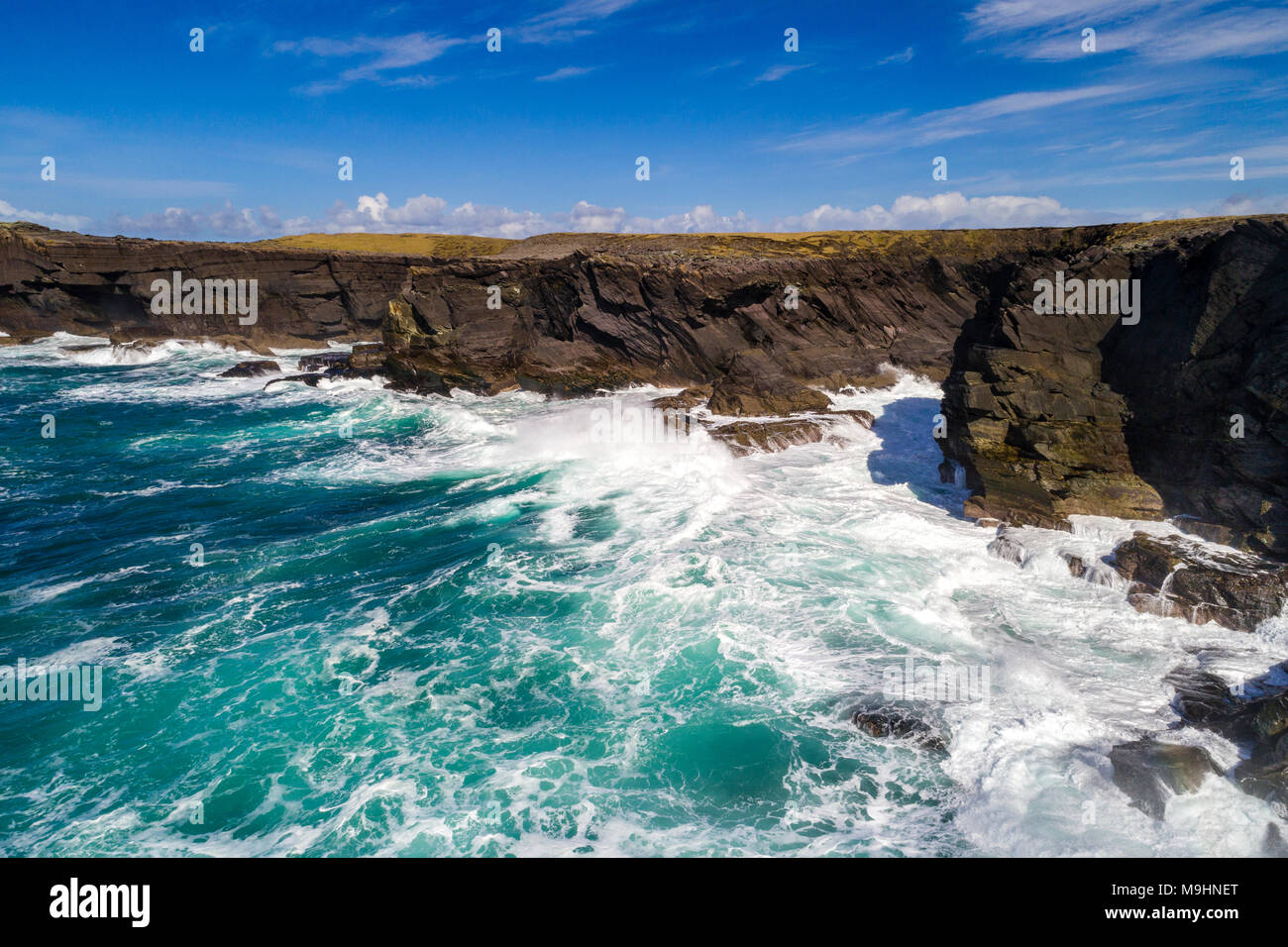 Wellen gegen die Klippen auf der Nordseite von Valentia Island, County Kerry, Irland Stockfoto