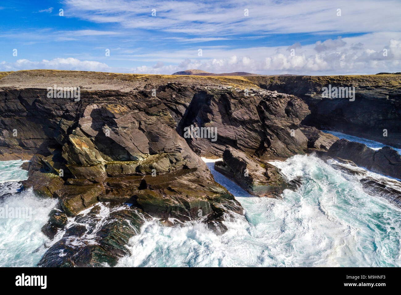 Wellen gegen die Klippen auf der Nordseite von Valentia Island, County Kerry, Irland Stockfoto