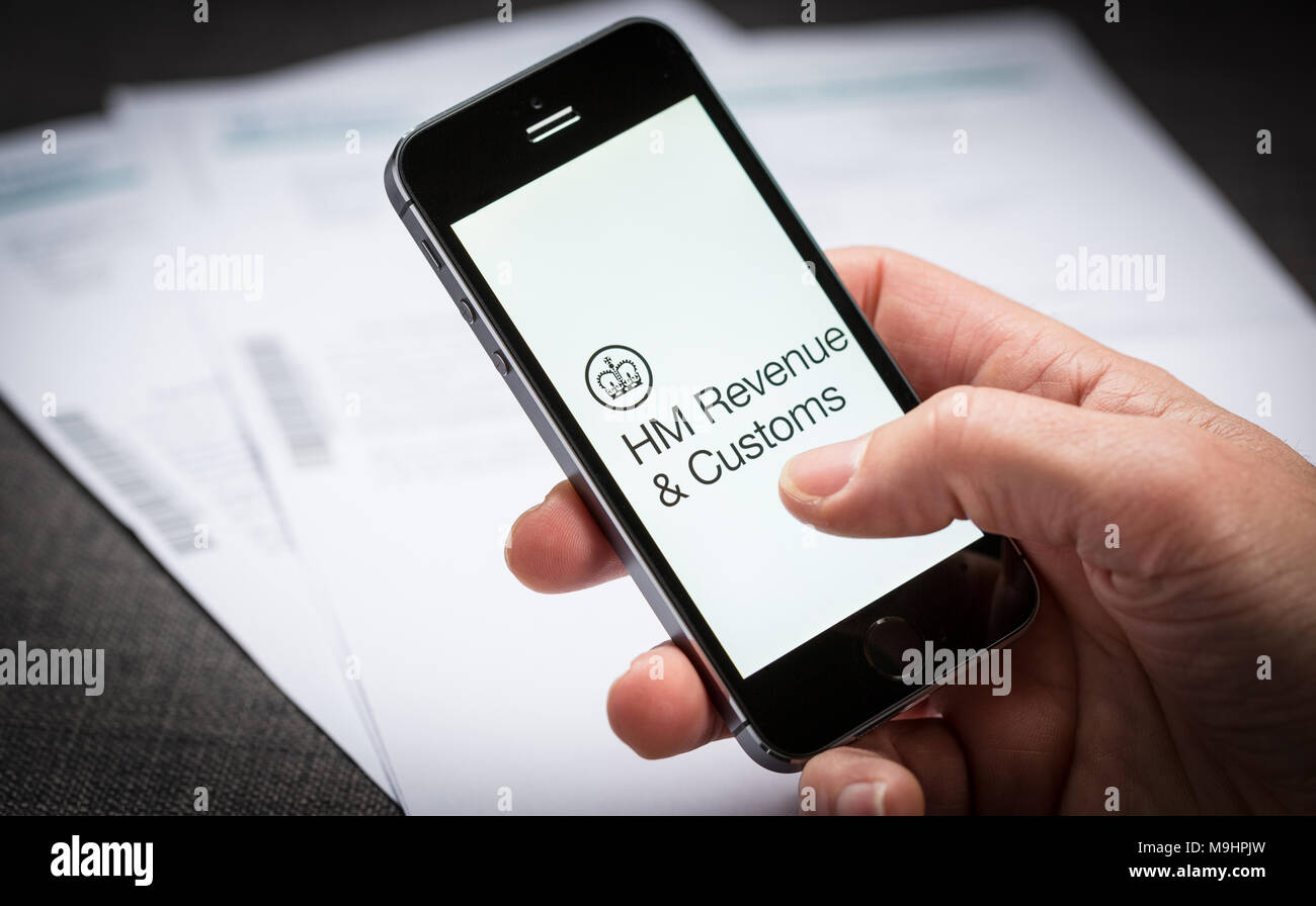 Ein Mann mit dem HMRC HM Einnahmen und Zoll App auf dem iPhone in Großbritannien Stockfoto
