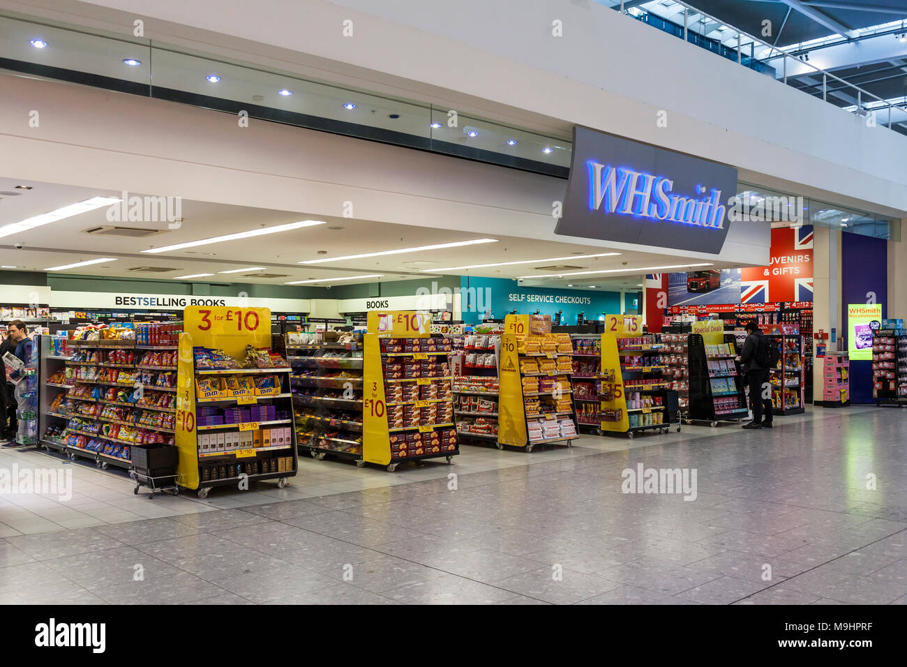WHSmith Retail Outlet am Flughafen Heathrow Terminal 5, Abflughalle. Großer Eingang mit Displays von Souvenirs und Süßwaren. Stockfoto