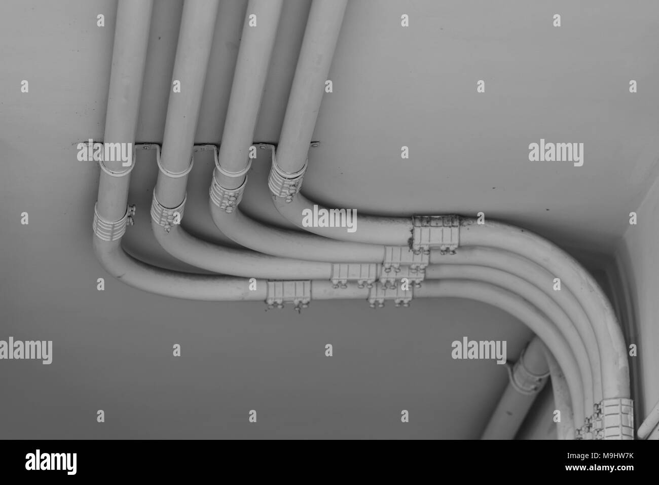 Leitung der Stromleitung auf Zement Wand in Schwarz und Weiß Ton Stockfoto