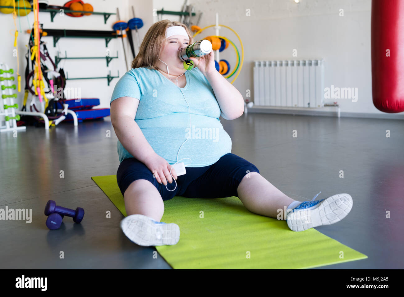 Beleibte Frau Trinkwasser nach dem Workout Stockfoto