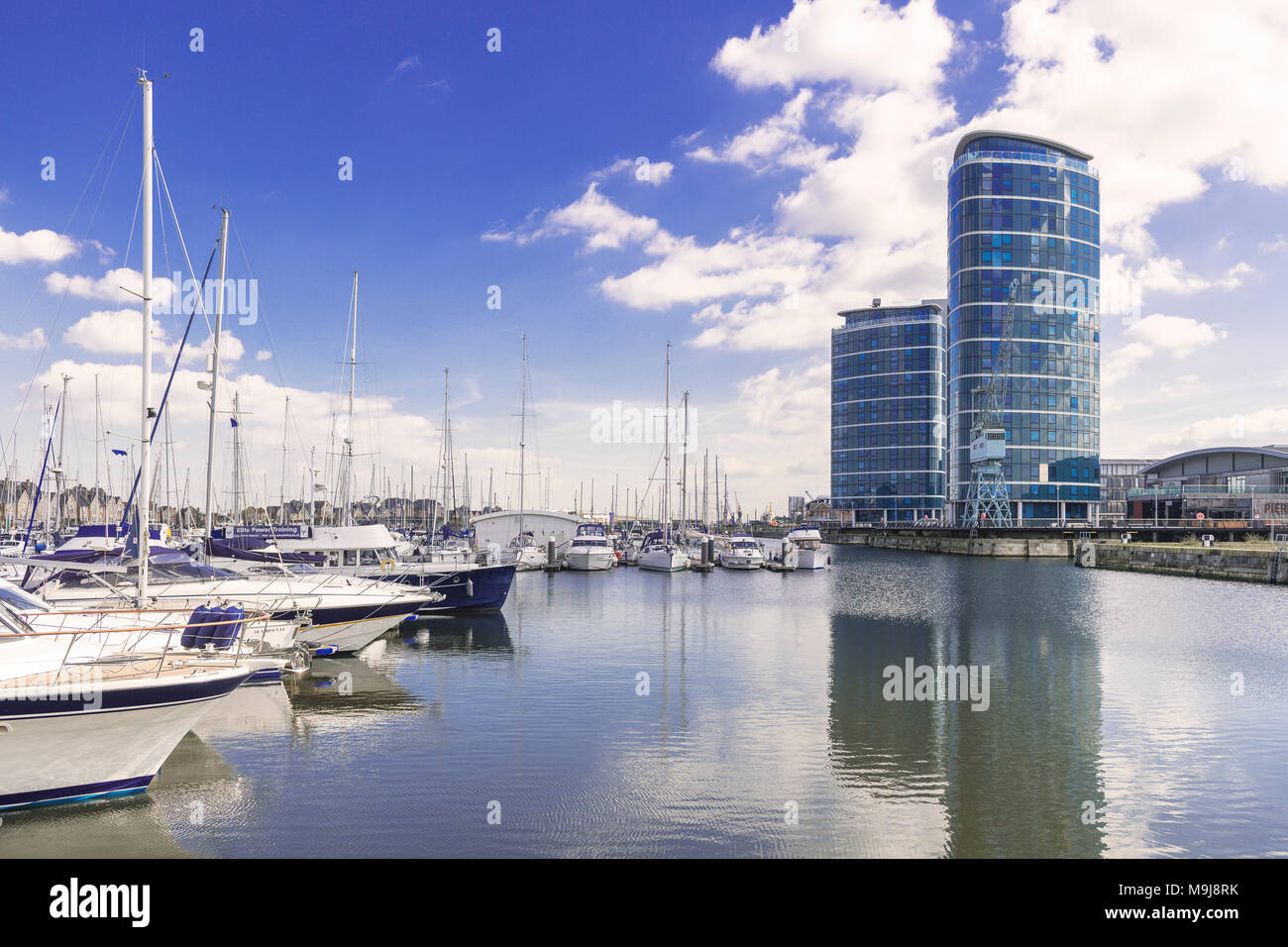 Boote und Yachten vor Anker an der Chatham Maritime Marina in Kent mit 2 Hochhäusern mit Blick auf die Marina Stockfoto