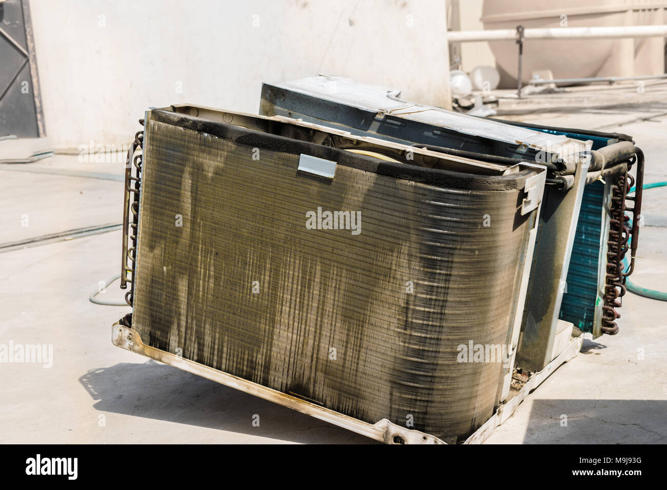 Spule aus einem Fenster klimaanlage ist verschmutzt und die Vorbereitung für die Reinigung auf dem Dach eines Hauses gehalten Stockfoto