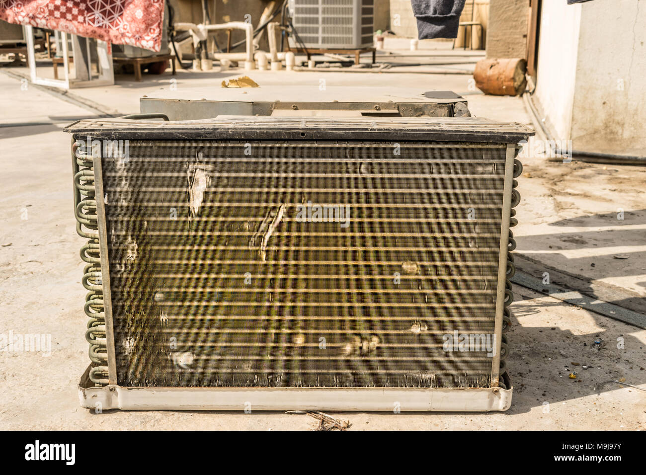Spule aus einem Fenster klimaanlage ist verschmutzt und die Vorbereitung für die Reinigung auf dem Dach eines Hauses gehalten Stockfoto