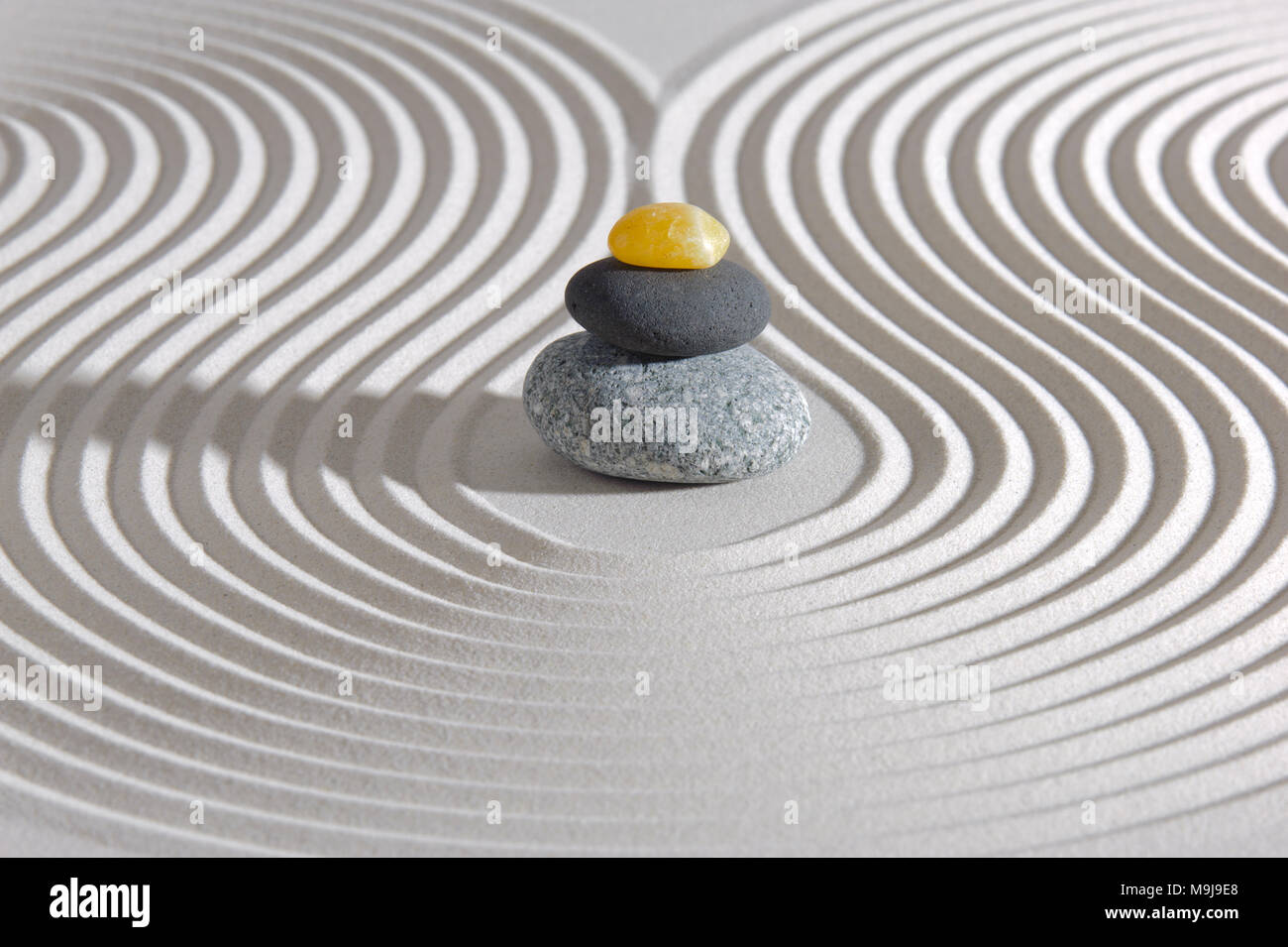 Japanischer Zen-Garten mit gestapelten Steinen in strukturierter Sand Stockfoto