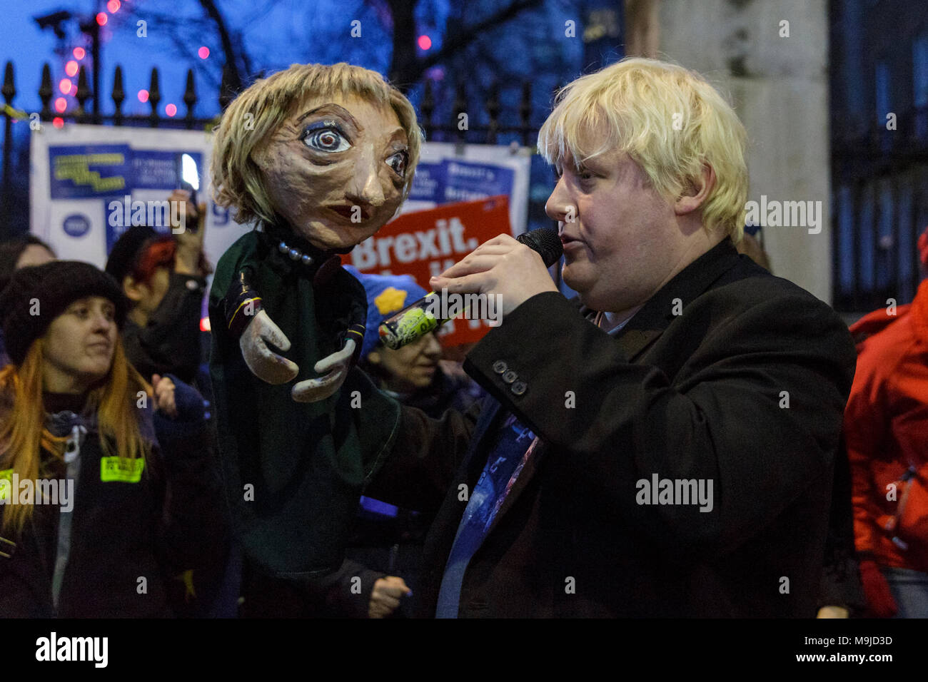 Westminster, London, 26. März 2018. Zeichnete Galdron, als Faux Bojo, Boris Johnson Imitator von London bekannt, tritt in die pro-europäische, Anti-Brexit Demonstranten vor Downing Street für einen Abend singalong mit seinem Theresa May Marionette. Credit: Imageplotter Nachrichten und Sport/Alamy leben Nachrichten Stockfoto