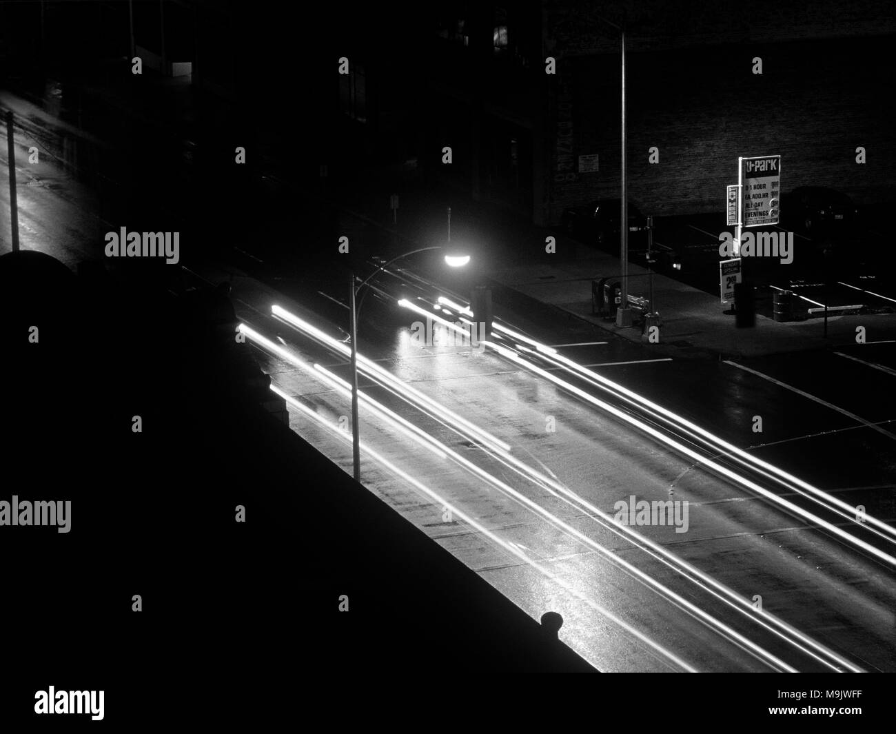 Straßenszene mit hellen Streifen in der Nacht unheimliches Gefühl in der Innenstadt in Schwarz und Weiß Stockfoto