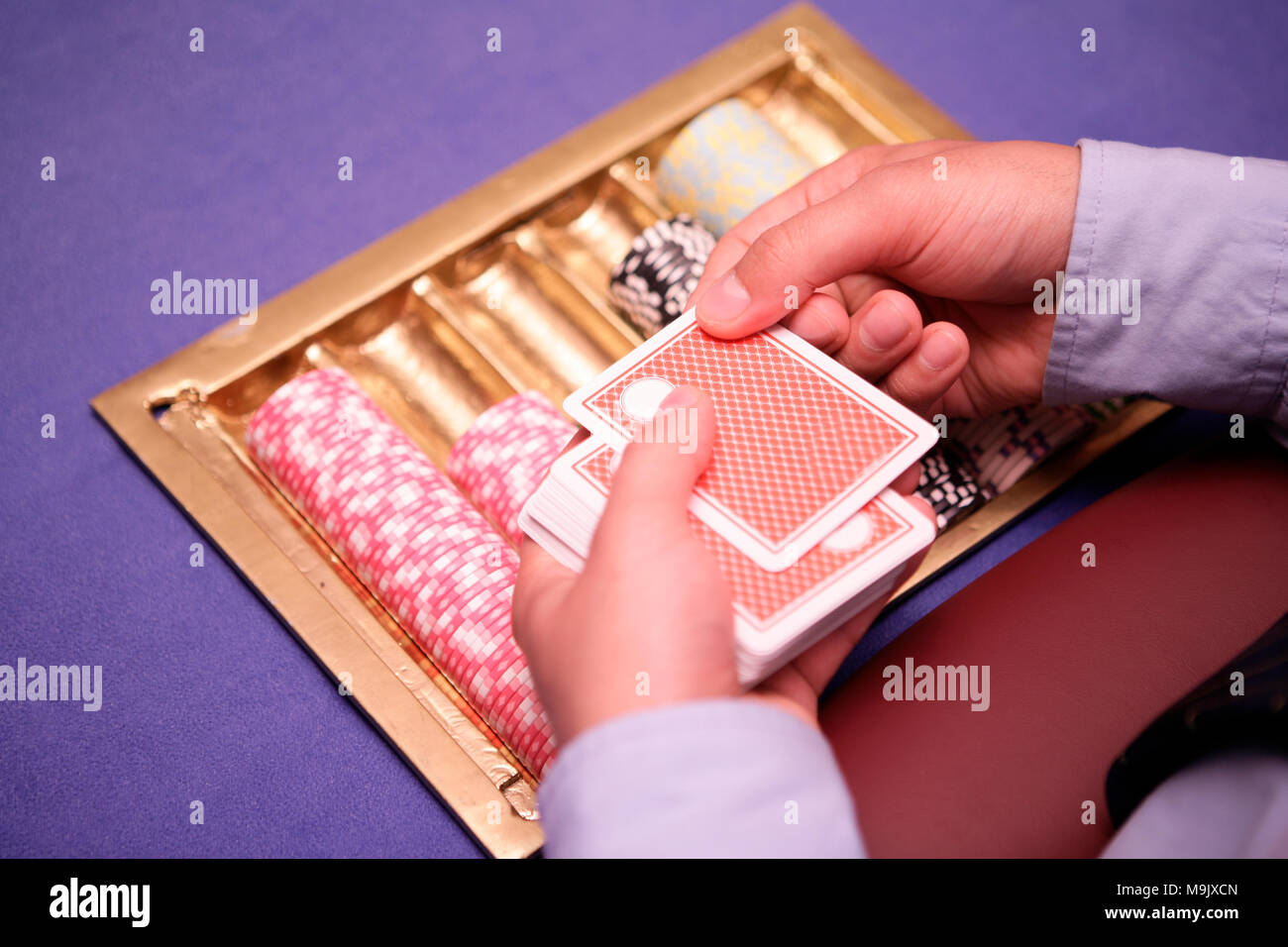 Nahaufnahme von holdem Dealer mit Spielkarten und Chips auf blauen Tabelle Stockfoto